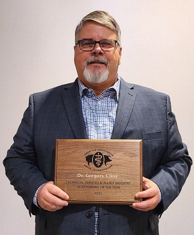 Dr. Gregory Cline holding plaque