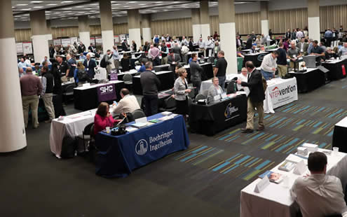 AASV Tech Tables exhibit showing tables, exhibit representatives, and attendees.