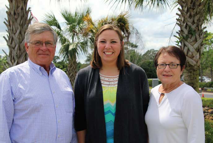 (a man and two women standing in front of palm trees)