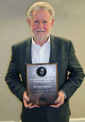 Dr. Davies holding award plaque