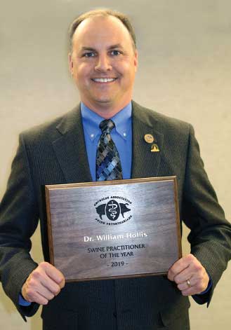 Dr. Hollis holding award plaque