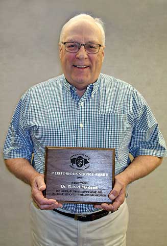 Dr. Madsen holding award plaque