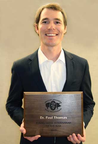 Dr. Thomas holding award plaque