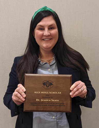 Jessica Seate holding scholarship plaque